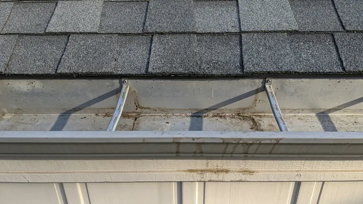 Gutter scooped out and flowing clear after gutter cleaning in Bellevue, WA