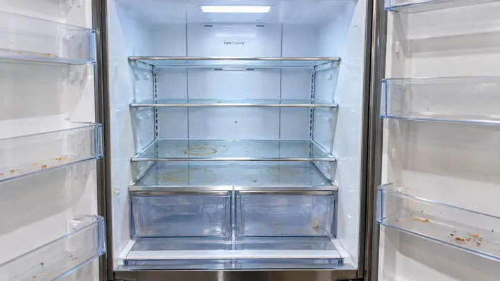 Refrigerator interior with food spills and stains on the shelves before a move-out clean in Bellevue, WA