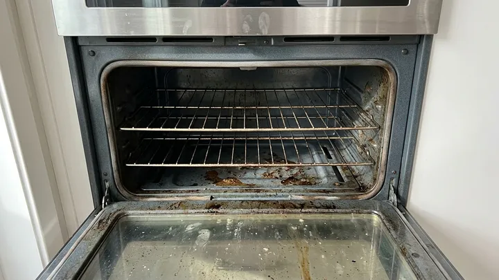 Oven interior coated in baked-on grease and burnt spills before a move-out clean in Kirkland, WA
