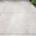 Concrete driveway with light dust and dirt before pressure washing