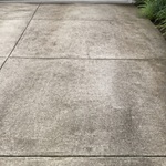 Concrete driveway with moderate grime or tire marks before pressure washing