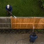 Both sides of a wood fence before double-sided pressure washing