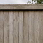 Faded, mildew-stained wood fence before pressure washing